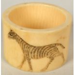 A Chinese ivory napkin ring decorated with a zebra, diameter 4cm.