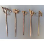 Five gold wishbone pins, one set a diamond, one peridot, the remainder set with pearls.