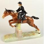 A Beswick equestrian model with a lady riding side saddle clearing a fence, height 25.5cm.