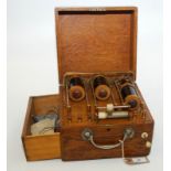 A triple coil, oak cased electrotherapy machine with accessory drawer.