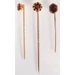 Three Victorian gold pins, each set with a garnet.