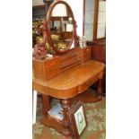 A Victorian mahogany dressing table, the oval mirror on carved supports and with miniature chests,