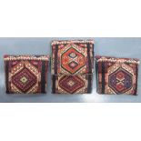 Four Persian kelim covered cushions, each decorated with serrated medallions,