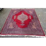 A Pakistan carpet, the red field with a central polychrome pole medallion, within multiple borders,
