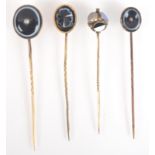 Three banded agate stick pins, one set with a diamond, together with a Victorian gold stick pin,