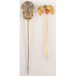 A high purity gold pin with a pair of leaves and a red coral berry,