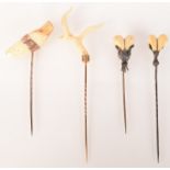 A gold mounted dogs tooth pin named Count together with two other tooth mounted pins and a white