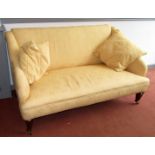 A Victorian small winged sofa upholstered in gold fabric on square section moulded legs,