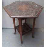 An Edwardian Arts and Crafts hexagonal occasional table with all over carving and a monogram at the