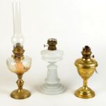 An Arts and Crafts brass oil lamp and two other oil lamps.