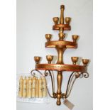 A three tier gilt wall sconce with nine candle nozzles.