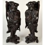 A pair of early 20th century carved figures depicting the Ho Ho Shen or genie of harmony and