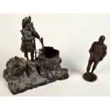 A small bronze figure of a gentleman holding a book and a cast 19th century inkstand, at the centre,