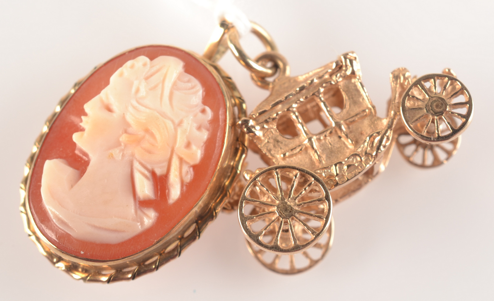 A gold carriage charm and a gold mounted cameo pendant/brooch.