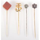 A gold S.J. monogram pin, a pearl onyx and crystal pin and an agate cube finial pin.