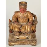 A Chinese mid 19th century wood carving of a house god in the form of an emperor seated upon a