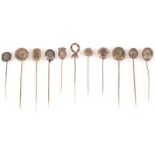 A collection of eleven gold and gilt mourning pins, each set with hair,