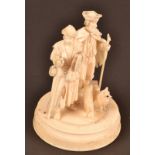 A late 19th century Dieppe ivory group of a couple wearing ragged clothes and each holding a staff,