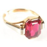 An 18ct gold ring set a red stone.