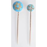 Two gold turquoise enamelled pins, the finial of each with a diamond set star.
