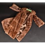 A brown coney, three quarter length fur coat, size 10-12.