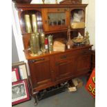 An Arts and Crafts walnut dresser, the upper section with elongated baluster end spindles,