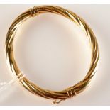 A contemporary 9ct. gold spiral fluted hinged bangle, 10g.