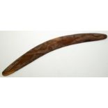 An Australian eucalyptus wood boomerang carved with central confronting lizards, length 57cm.