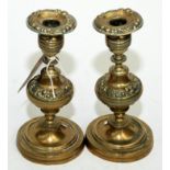 A pair of mid 19th century ornate brass candlesticks.