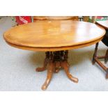 A late Victorian cross-banded walnut oval tilt-top salon table, 117cm wide,