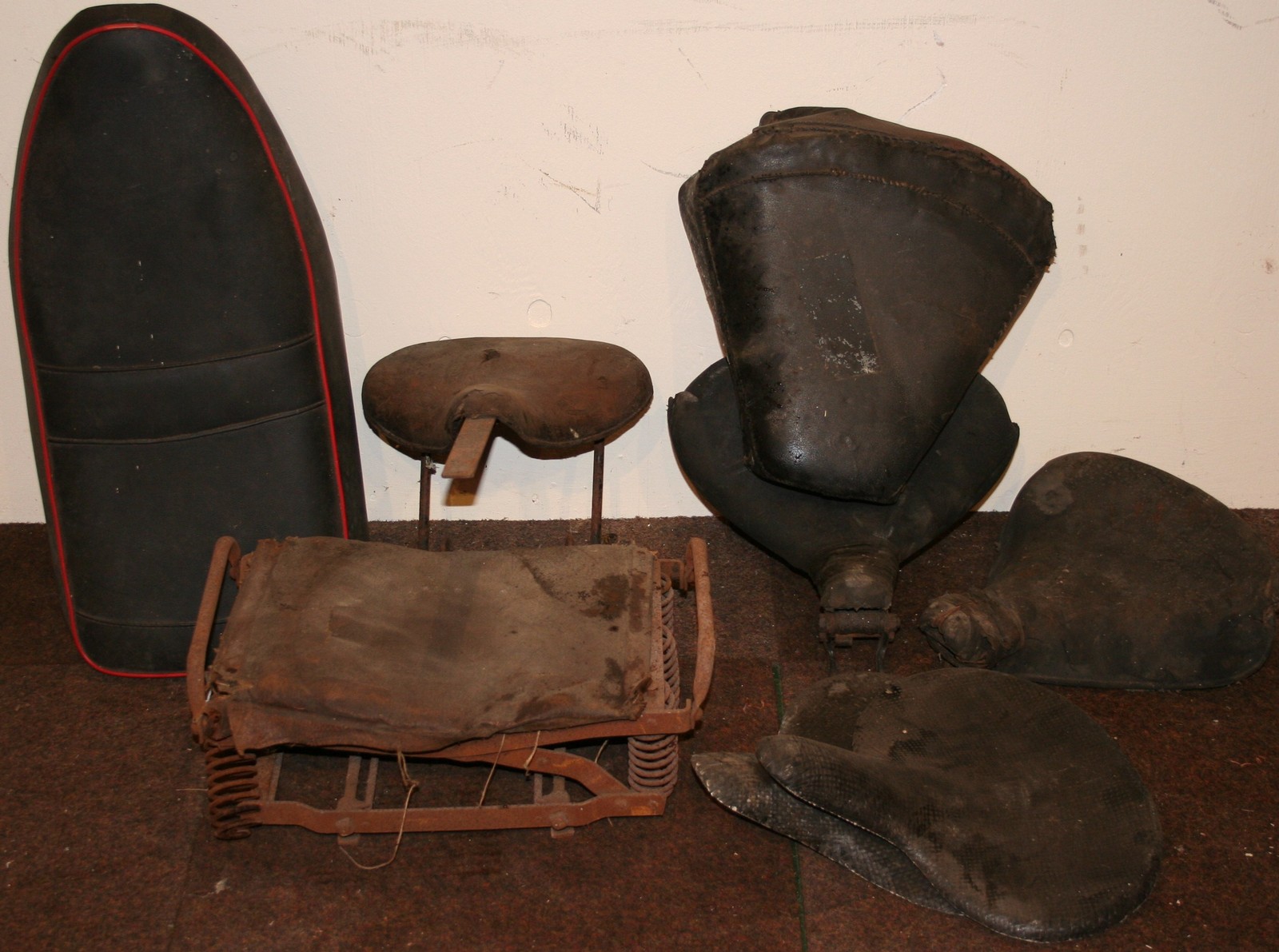 A pre 1930's sprung seat, a sprung rear seat and other seats.