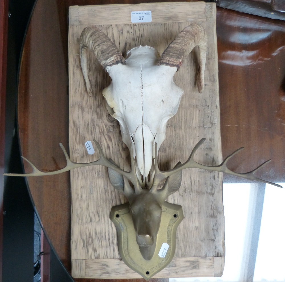 A rams skull mounted on wooden plaque, together with a brass stags head on brass mount (2)