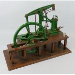 A cash-iron model of a factory beam engine, the green painted framework and fly-wheel with brass and