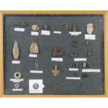 A frame display of metal detector Medieval finds, including spindle whorl, coins, buckles, weights