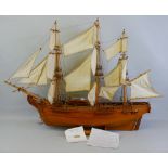 A wooden model of HMS Bounty, with teak hull, deck and fittings and linen sails with rigging, with