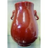 A Chinese red glaze bulbous vase, with elephant mask handles, 27cm high