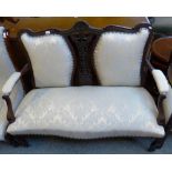 A similarly upholstered Edwardian carved mahogany framed double chair-back settee