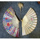 Two Chinese fans, the first with pierced bone sticks and feathers, the second with a silk floral