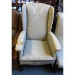 A similarly upholstered early 20th century wing armchair