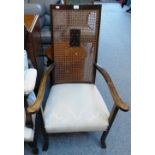 An early 20th century stained birch cane back armchair, with pale blue damask upholstery