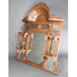 An Edwardian multiple plate over mantel mirror contained in a heavily carved arched walnut frame