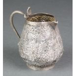 An Indian repousse silver jug with animals in a forest setting and serpent handle 144 grams 3 1/2"