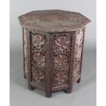 An octagonal Indian pierced and carved hardwood folding occasional table the top heavily carved