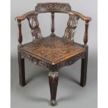 A Georgian oak corner chair with slatted back, raised on cabriole and square legs all heavily carved