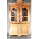 A 19th Century French pine cabinet on cabinet, the upper section with shaped cornice, the base