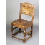 A 17th/18th Century oak chair of joined construction and solid seat, the arched back marked H L I,