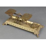 A pair of 19th Century gilt metal postal scales raised on a rectangular base with hoof supports,