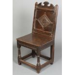 A 17th Century oak high back chair of joined construction raised on turned and block supports (