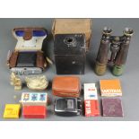 A pair of field glasses, a Dacora folding camera, a Portrait Hawk Eye no.2 box camera, an Agfa flash