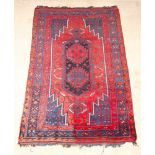 A blue and red ground Kurdish rug with lozenge shaped medallion to the centre 97" x 63", in wear